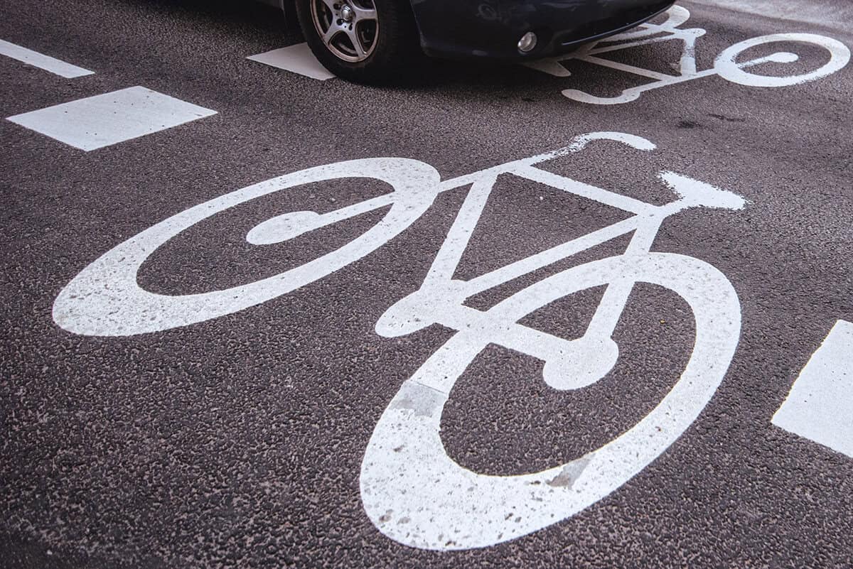 Car passing over bicycle lane sign on the road, traffic situation on zebra crossing